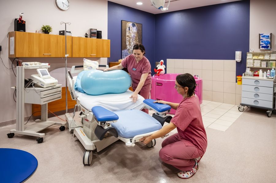 Kreißsaal mit zwei Hebammen und Gebärwanne